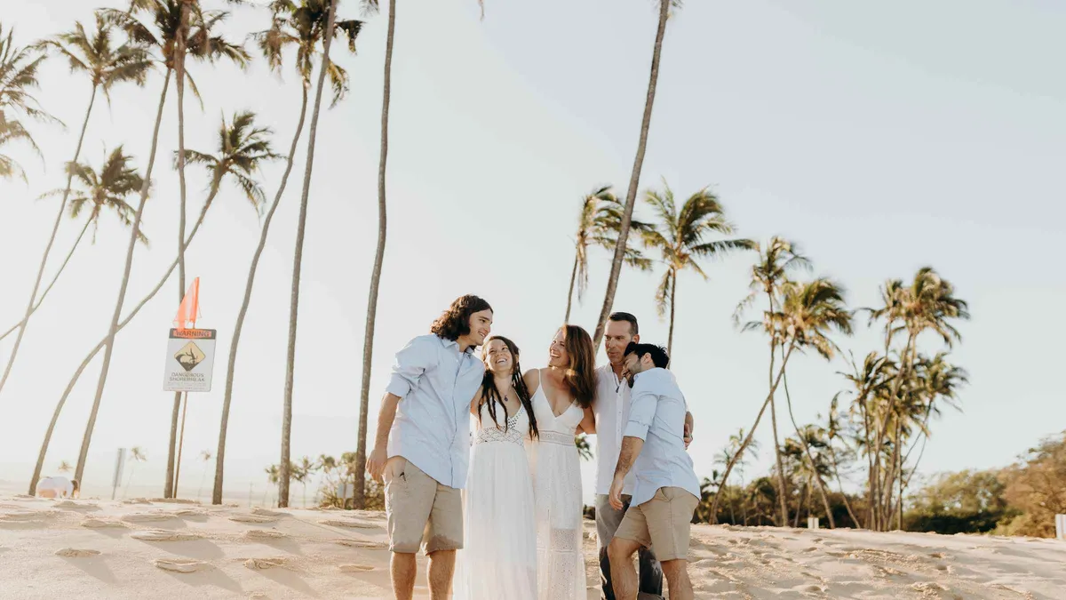 A vetted local photographer photographing a family at a scenic beach during a private Maui photoshoot session